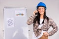 A woman architect is talking on the phone and smiling at the camera against the backdrop of an office project. Gender Royalty Free Stock Photo