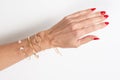 Woman arm hand with jewelry on white background in top view and red nails Royalty Free Stock Photo