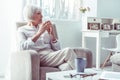 Beautiful elegant retired woman sitting in armchair waiting for husband