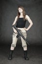 Woman armed with American rifle standing on black