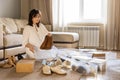 Woman arrangement shoes into plastic container and cardboard box seasonal storage organizing closeup Royalty Free Stock Photo