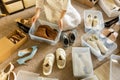 Woman arrangement shoes into plastic container and cardboard box seasonal storage organizing closeup Royalty Free Stock Photo