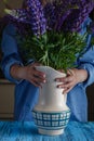 Woman arranges spring flower bouquet in a vase