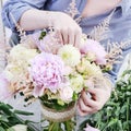 Woman arranging bouquet with pink peonies, roses and yellow dahlias Royalty Free Stock Photo