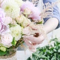 Woman arranging bouquet with pink peonies, roses and yellow dahlias Royalty Free Stock Photo