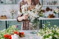 Woman arranging bouquet, putting it in glass jar Royalty Free Stock Photo