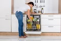 Woman Arranging Plates In Dishwasher