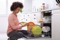 Woman Arranging Plates In Dishwasher