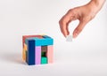 Woman arranging puzzle cube by putting missing element. Construction, formation or successful work completion concept