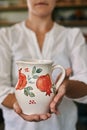 woman artisan ceramist holding a beautiful hand-painted clay jug