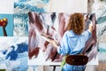 Woman artist drawing on canvas with brush in studio Royalty Free Stock Photo