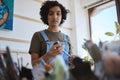 Woman artist in her art workshop with paint brush and search for inspiration for artwork. Young, Indian professional Royalty Free Stock Photo