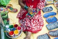 A woman artist painted on a earthen pot in a fair.