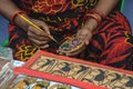 A woman artist painted on a earthen pot in a handicraft fair.