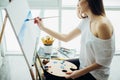 Woman artist painting a picture in a well-lit studio Royalty Free Stock Photo