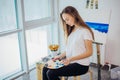 Woman artist painting a picture in a well-lit studio Royalty Free Stock Photo