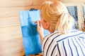 Woman artist paints picture on canvas in wooden house. Hobby painting