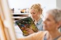 Woman artist with palette painting at art school