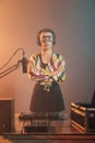 Woman artist posing with arms crossed at turntables