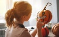 Woman artist prepares for halloween and paints pumpkins Royalty Free Stock Photo