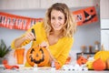 woman artist prepares for halloween and paints pumpkins Royalty Free Stock Photo