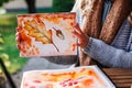 Woman artist shows her watercolor painting with an autumn theme