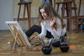 Woman artist sits on the floor in an art studio and paints Royalty Free Stock Photo