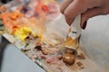 A woman artist squeezes oil paint onto a palette from a tube. Royalty Free Stock Photo