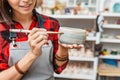 Woman artist in working apron paints with brush a decorative ceramic pottery in workshop Royalty Free Stock Photo