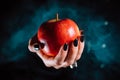 Woman as witch offers red apple - symbol of toxic proposal, lure. Royalty Free Stock Photo