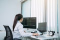 Woman asian software developers are analyzing together about the code written into the program on the computer in office room
