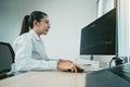Woman asian software developers are analyzing together about the code written into the program on the computer in office room