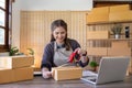 Woman asian use scotch tape to attach parcel boxes to prepare goods for the process of packaging, shipping, online sale