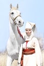 Woman in asian white national dress with white horse in nature Royalty Free Stock Photo