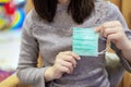 Woman / asin lady is holding and show folded medical mask by two hands before wear for protect the virus