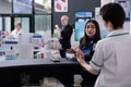 Woman asking pharmacy cashier about sunscreen at counter desk Royalty Free Stock Photo