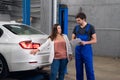 A woman asks a mechanic about a car repair Royalty Free Stock Photo