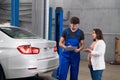 A woman asks a mechanic about a car repair Royalty Free Stock Photo