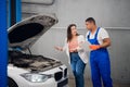 Woman asks mechanic to fix car engine Royalty Free Stock Photo