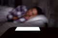 Woman Asleep In Bed At Home With Mobile Phone Lit Up On Bedside Table Royalty Free Stock Photo