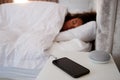 Woman Asleep In Bed With Mobile Phone And Voice Assistant On Bedside Table Royalty Free Stock Photo