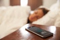 Woman Asleep In Bed Woken By Alarm On Mobile Phone Royalty Free Stock Photo