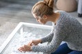 Woman assembling puzzle on glass table at home