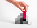 Woman assembling tetris puzzle. Hand putting outstanding red element in black and white construction. Formation concept