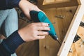 Woman assembly wooden furniture,fixing or repairing house with drill tool.modern living concepts