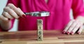 Woman assessing risk from wooden cubes with magnifying glass closeup 4k movie slow motion