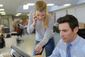 Woman assisting male computer clerk Royalty Free Stock Photo