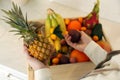 Woman with assortment of exotic fruits at table in kitchen, closeup Royalty Free Stock Photo