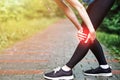 Woman athlete runner touching Knee in pain, fitness woman running in summer park. Healthy lifestyle and sport concept Royalty Free Stock Photo