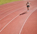 Woman, athlete and running on stadium in fitness, workout or cardio exercise for practice or training on track. Female Royalty Free Stock Photo